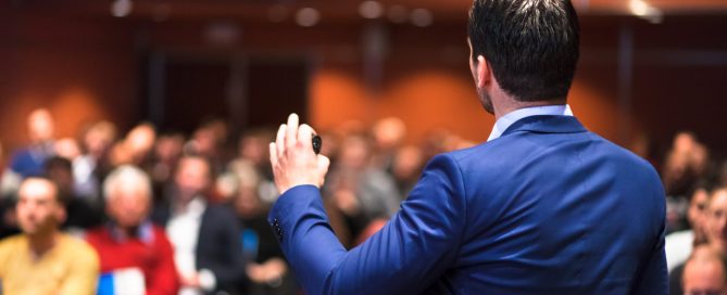 Public speaker giving talk at Business Event.