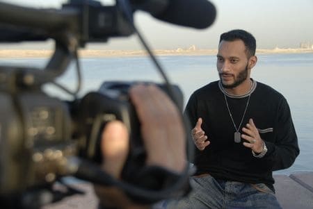 9 Ways Website Video Streams Help Your Business Thrive A man being filmed talking with the ocean as a backdrop.