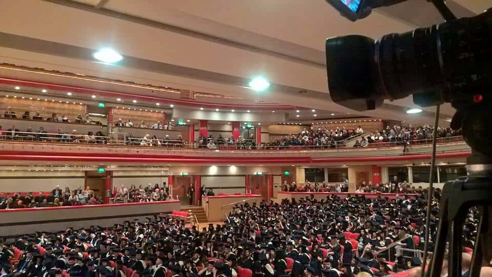 Live streaming graduation A very large conference in an old music hall. Attendees are already at their seats,